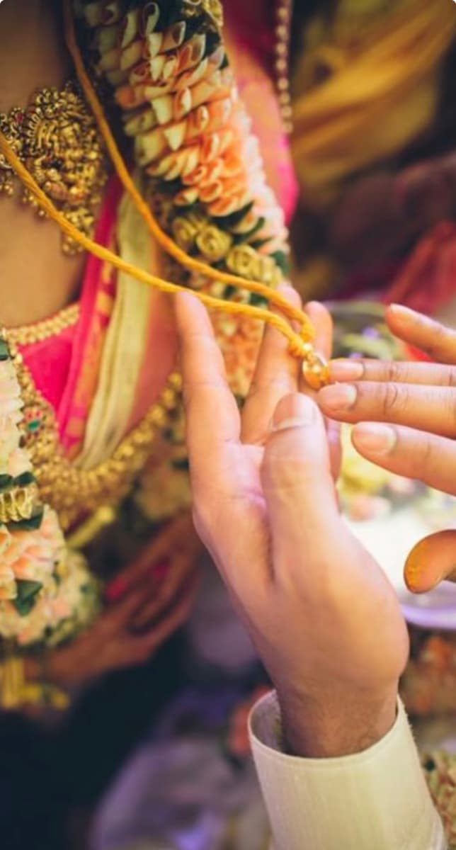 A groom tying the mangalsutra during a wedding ceremony